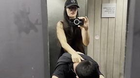 Dominant brunette fucks her boyfriend with a strap on in a public toilet